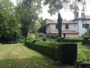 a garden with a hedge in front of a house at Moulin Rouhaud in Montboyer