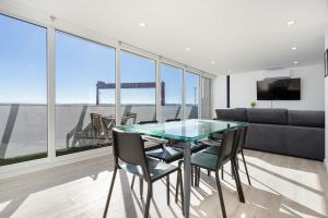 une salle à manger avec une table et des chaises en verre dans l'établissement Cacilhas Riverview!, à Almada