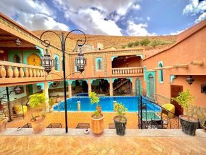 a large building with a swimming pool in front of it at Dar Ahlam Dades Hotel in Aït Ouaddar