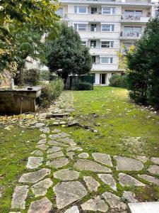 a stone walkway in a yard in front of a building at Mytripinparis - Sablons in Neuilly-sur-Seine