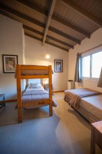1 dormitorio con 2 camas y ventana grande en La Posta de los Toldos en Perito Moreno