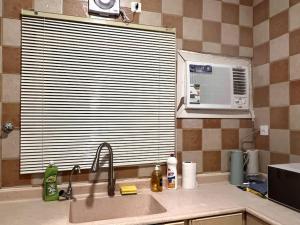 a kitchen with a sink and a microwave at Ban Luxury Apartments in Al Khobar
