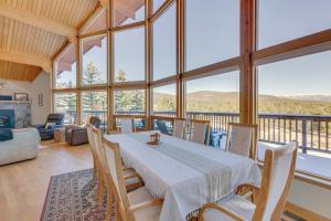 a dining room with a table and chairs and windows at Spacious Angel Fire Retreat 3 Mi to Ski Resort in Angel Fire