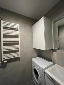 a laundry room with a washing machine and a sink at BEMA Guest House - City Centre in Wrocław