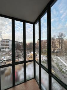 a room with four windows with a view of a city at BEMA Guest House - City Centre in Wrocław