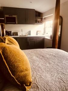 a room with a kitchen and a bed in a room at The Old Post Office Studio Apartment in a Beautiful Cotswold Village in Cirencester