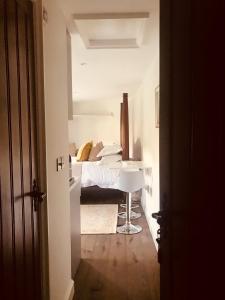 a bedroom with a bed and a table in it at The Old Post Office Studio Apartment in a Beautiful Cotswold Village in Cirencester