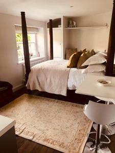 1 dormitorio con 1 cama grande y 1 alfombra en The Old Post Office Studio Apartment in a Beautiful Cotswold Village en Cirencester