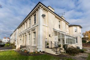 um grande edifício branco com janelas grandes em 10 Sydenham - By Luxury Apartments em Cheltenham