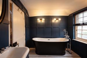 a black bathroom with a tub and a sink at The Manor House in Port Isaac