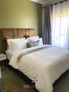 a bedroom with a large white bed with a window at Nid de Rêve Accommodation in Midrand