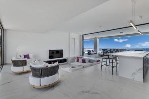 a living room with white furniture and a view of the ocean at Villa Regatta in Kralendijk
