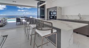 a kitchen with a long counter with bar stools at Villa Regatta in Kralendijk