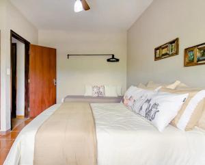 a large white bed in a white bedroom at The Cats' House in Florianópolis