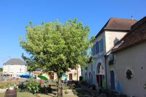 un árbol frente a un edificio con un árbol en Terre de Brenne, en Azay-le-Ferron
