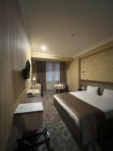 um quarto de hotel com uma cama e uma secretária em Royal Boutique Baku em Baku