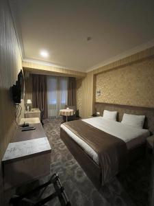 巴庫的住宿－Royal Boutique Baku，酒店客房设有一张大床和一张书桌。