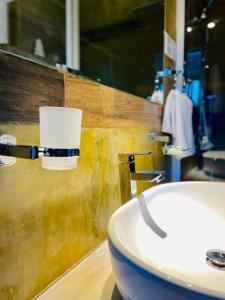 a bathroom with a sink and a toilet paper holder at 8 Plus Motels in Negombo