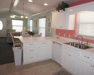 a kitchen with white cabinets and a sink at Venture Out 402 North Marlin Dr WITH GOLF CART in Panama City Beach