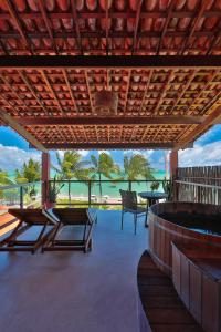 a patio with a view of the beach and the ocean at Pousada Rota Ecológica in Pôrto de Pedras