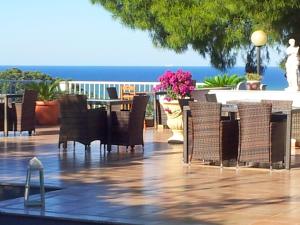 a patio with chairs and a table with the ocean in the background at Residence Maresol in Vieste