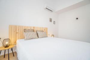 a bedroom with a white bed with a wooden headboard at 405-Casa al canal con amarre in Empuriabrava