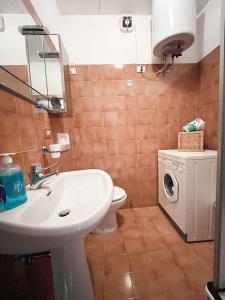 Appartamento Bresimo في Bresimo: حمام مع حوض ومرحاض وغسالة