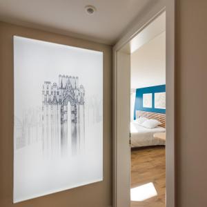 a bedroom with a framed picture of a building at Studios de la Nuée Bleue in Strasbourg