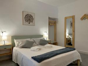 1 dormitorio con 1 cama grande y espejo en Apartamentos El Búho, en Belmonte