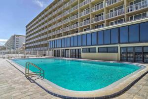 a large swimming pool in front of a building at Breezy Daytona Beach Studio with Balcony and Views! in Daytona Beach