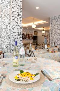 a table with a plate of food and bottles on it at Hotel Centrale Miramare in Rimini