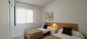 een kleine slaapkamer met twee bedden en een raam bij Amanecer 7 Alicante in Orihuela +37 foto's