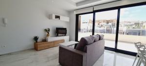 een woonkamer met een bank en een televisie bij Amanecer 7 Alicante in Orihuela