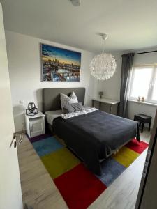 een slaapkamer met een bed en een kleurrijk tapijt bij Work and Stay Erlensee in Erlensee