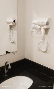 a bathroom with a sink and a phone on the wall at Pousada Estrela de Davi in Penha