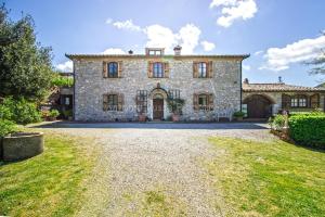 an exterior view of a large stone house with a yard at Ca'Novae - Tuscany Farmhouse in Montieri