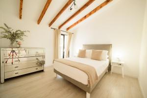 貝尼塔切利的住宿－Mirasol，一间白色卧室,配有一张床和一个梳妆台