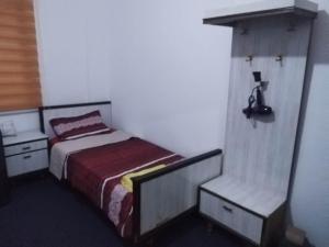 ein kleines Schlafzimmer mit einem Bett und einem Stuhl in der Unterkunft City Center in Gerasa