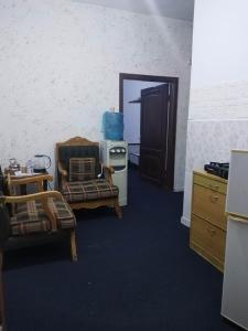ein Wohnzimmer mit 2 Stühlen und einer offenen Tür in der Unterkunft City Center in Gerasa