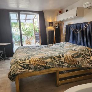 een slaapkamer met een bed met een dekbed erop bij coconbleu, balnéo double in Solliès-Toucas