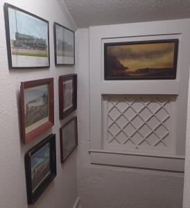 una pared con cuadros enmarcados en una pared en 3-Br 2-Bath Family-Friendly Home -10 Min to Tulsa en Tulsa
