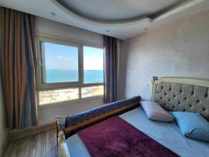 a bedroom with a bed with a view of the ocean at Amazing Sea View 2 bedroom apartment in Alexandria