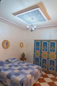 a bedroom with a blue and white bed and a ceiling at Hostel artistic airport in Marrakech