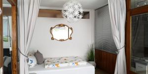 ein Schlafzimmer mit einem Spiegel und einem Kronleuchter in der Unterkunft Ferienwohnung Naturpur in Rheinau