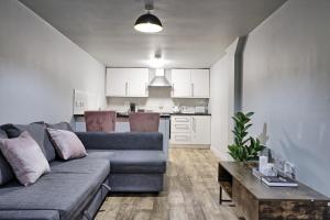 a living room with a couch and a kitchen at Deluxe Large Three Room Apartment by Southend Stays in Southend-on-Sea