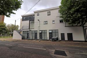 a white building with glass windows on a street at Deluxe Large Three Room Apartment by Southend Stays in Southend-on-Sea
