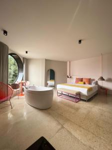 Del Trópico sopetrán في سوبيتران: غرفة نوم كبيرة بها سرير وحوض استحمام