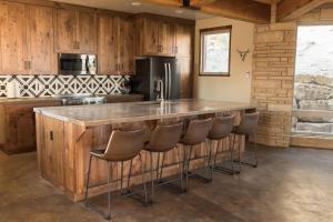 a kitchen with a large counter with stools in it at Escalante Cliff House in Escalante