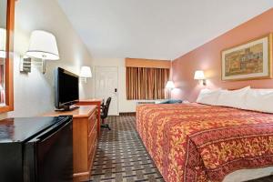 Habitación de hotel con cama y TV de pantalla plana. en Day Star Dallas en Dallas
