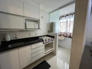 a small kitchen with white cabinets and a sink at Água Campos in Campos dos Goytacazes